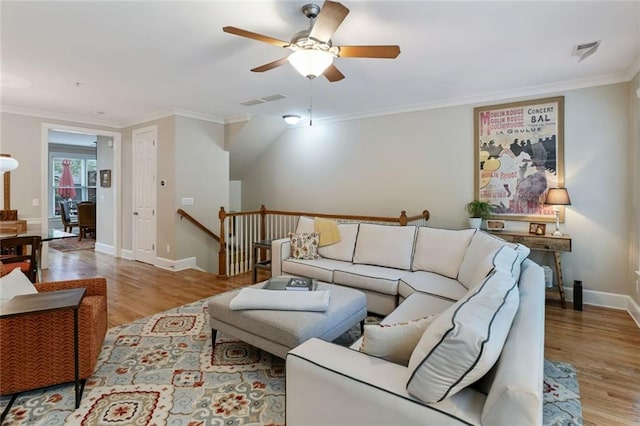 living room featuring visible vents, a ceiling fan, baseboards, and wood finished floors