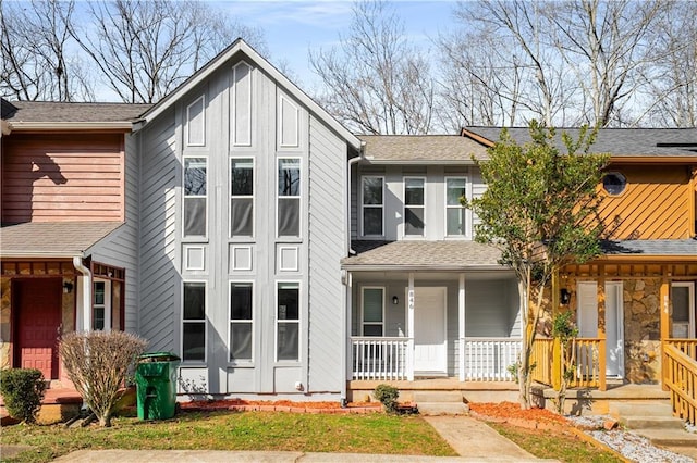 view of front facade featuring board and batten siding, covered porch, and a shingled roof