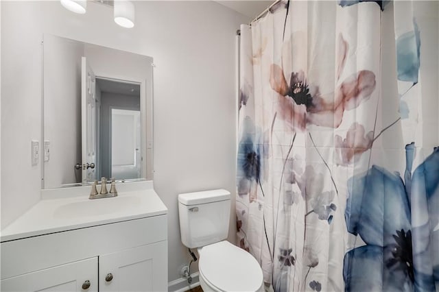 bathroom with toilet, curtained shower, and vanity