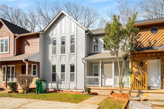 view of front facade with a porch, board and batten siding, and roof with shingles