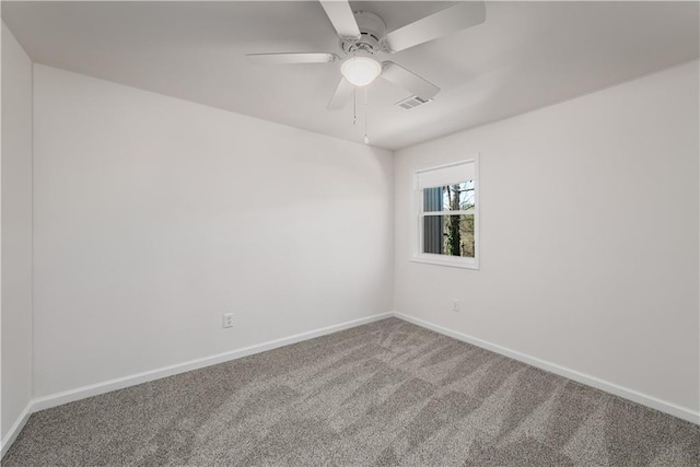 carpeted spare room featuring baseboards, visible vents, and ceiling fan