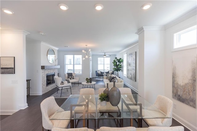 dining area featuring ceiling fan with notable chandelier, crown molding, and dark wood-type flooring