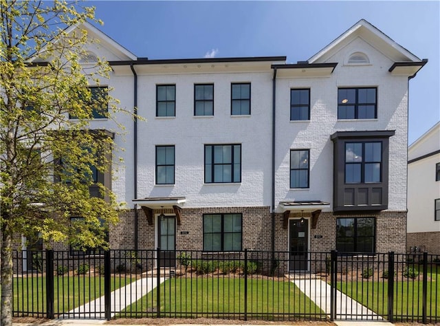 townhome / multi-family property featuring a front lawn