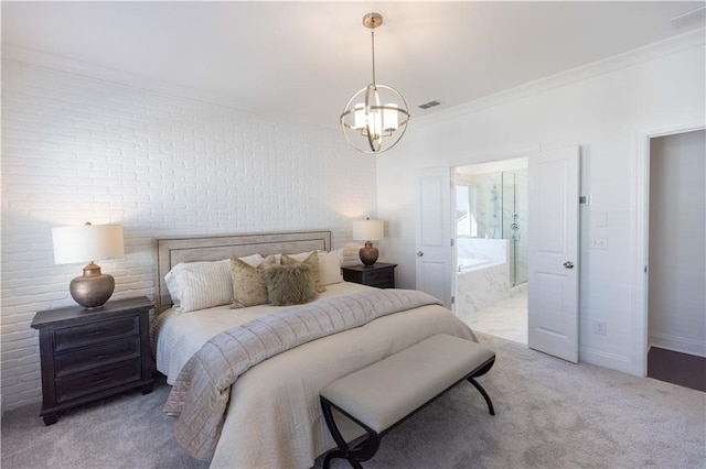 carpeted bedroom with a notable chandelier, crown molding, brick wall, and connected bathroom