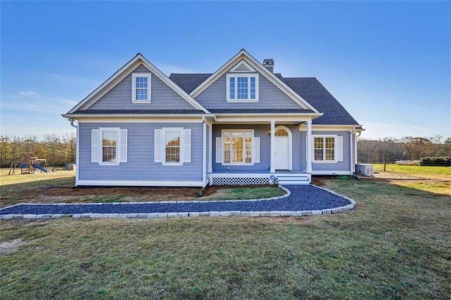 view of front of home with central AC, a porch, a playground, and a front lawn