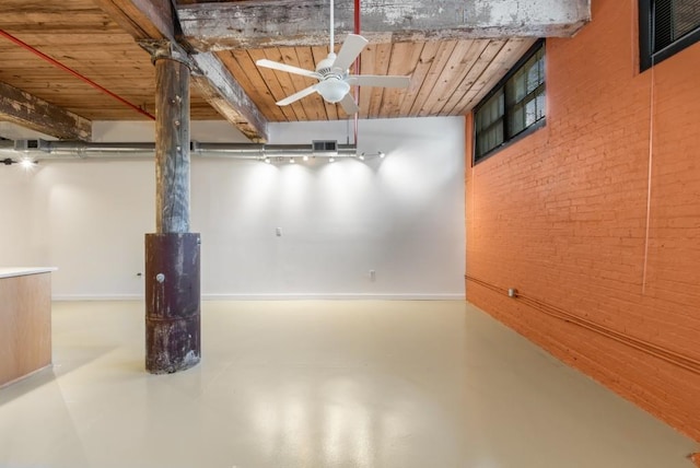 basement featuring a ceiling fan, an accent wall, wood ceiling, brick wall, and visible vents