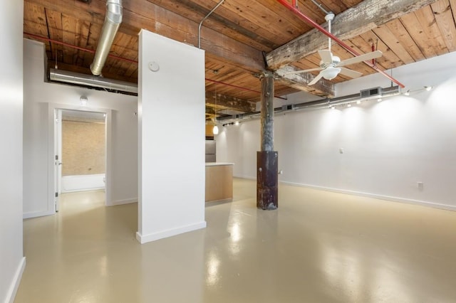 below grade area with visible vents, a ceiling fan, wooden ceiling, freestanding refrigerator, and baseboards