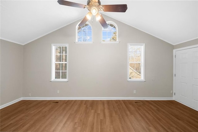 additional living space with wood finished floors, visible vents, baseboards, ceiling fan, and vaulted ceiling