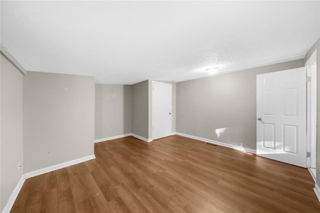 empty room featuring visible vents, baseboards, and wood finished floors