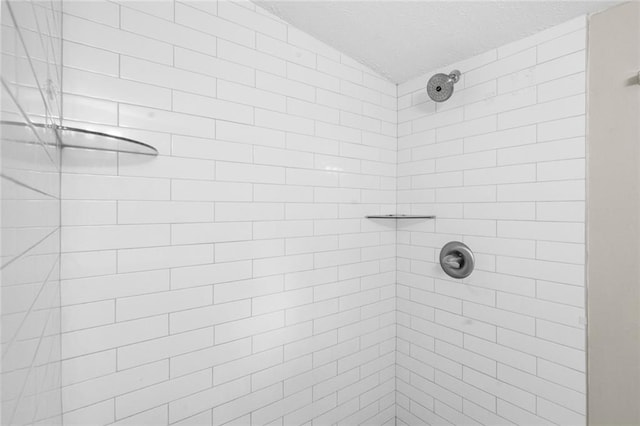 full bath with lofted ceiling, a textured ceiling, and a tile shower