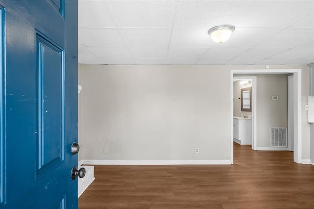 interior space featuring a drop ceiling, visible vents, and wood finished floors