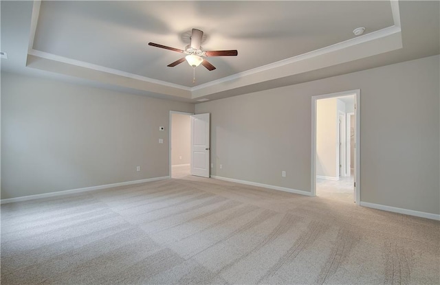 616 Gratton Ln, Mcdonough, GA 30253 - spare room featuring a raised ceiling, a ceiling fan, ornamental molding, and light carpet