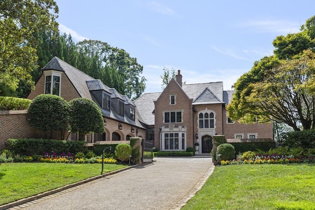 english style home featuring a front yard