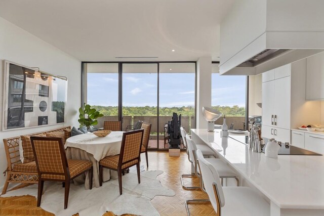 dining space with expansive windows and light parquet flooring