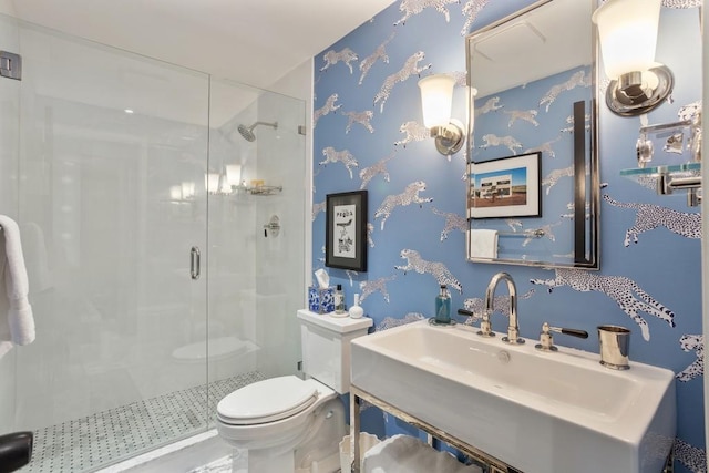 bathroom featuring sink, toilet, and a shower with shower door