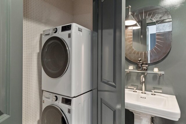 laundry area featuring sink and stacked washer / drying machine