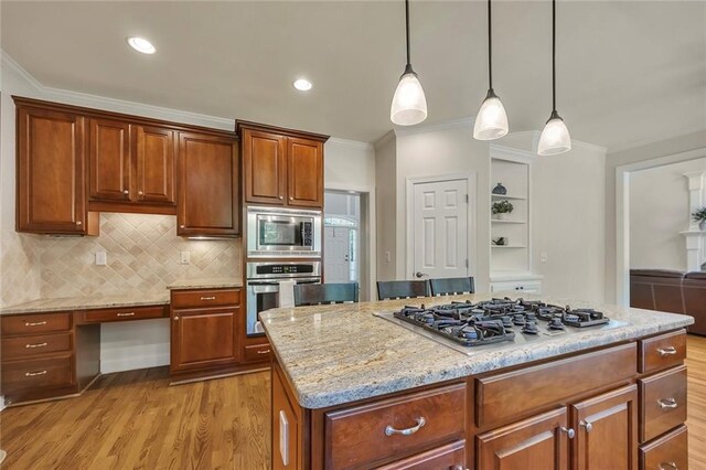 kitchen featuring stainless steel appliances, ornamental molding, light wood-type flooring, pendant lighting, and light stone countertops