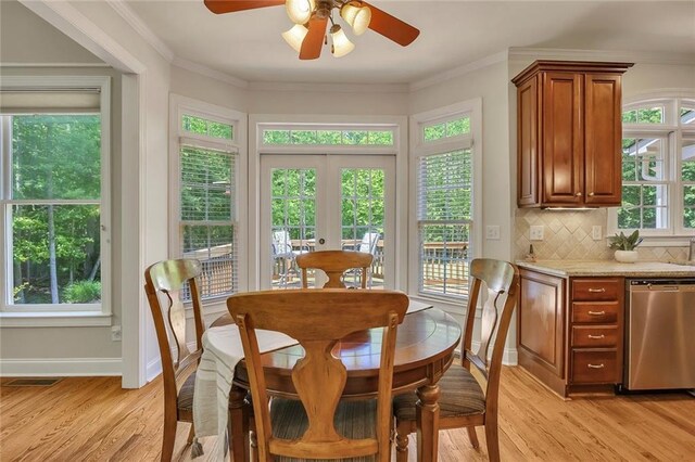 dining area featuring light wood-type flooring, ceiling fan, baseboards, and ornamental molding