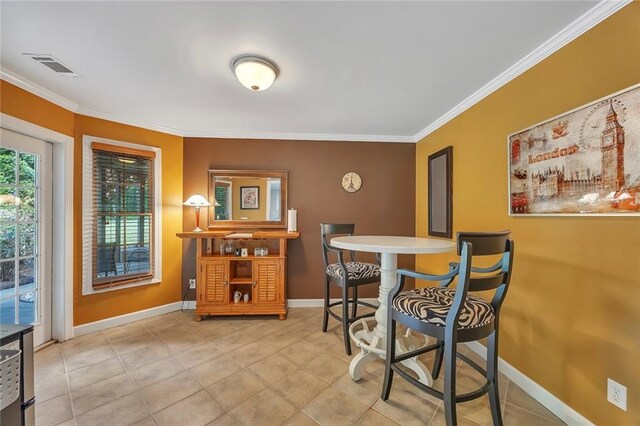 dining room featuring ornamental molding, baseboards, and light tile patterned floors