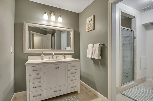 bathroom featuring a shower stall, vanity, tile patterned floors, and baseboards