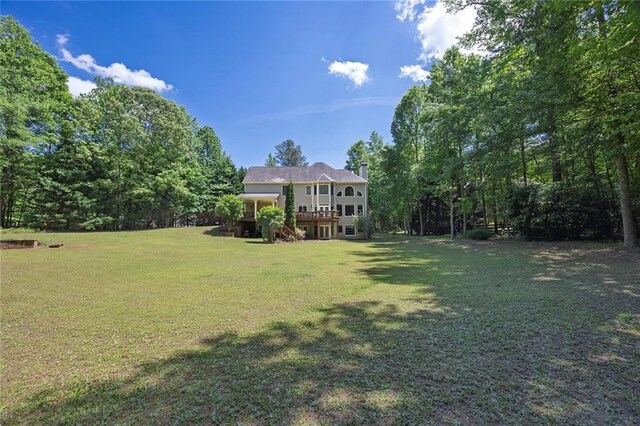 view of grassy yard featuring a wooden deck and stairs