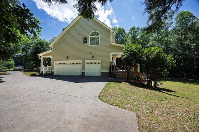 view of side of property featuring a garage, driveway, and a yard