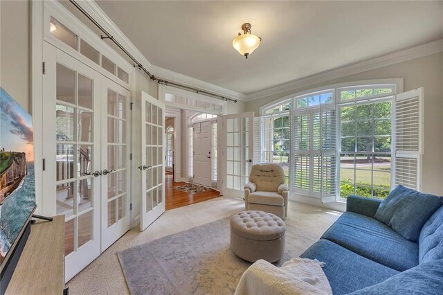 living area with french doors, ornamental molding, and carpet floors