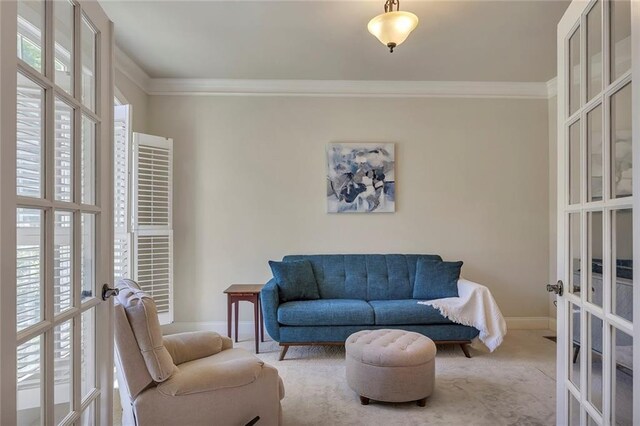 sitting room with french doors, crown molding, baseboards, and carpet