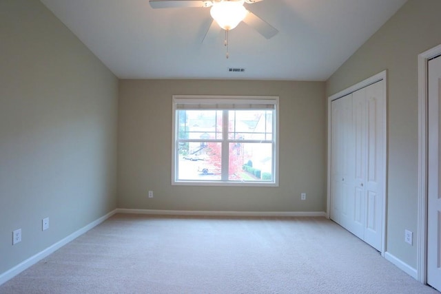 unfurnished bedroom featuring ceiling fan, light colored carpet, and a closet