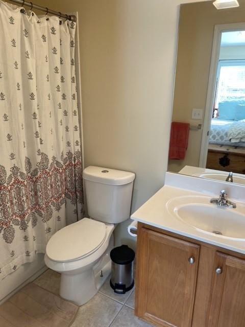 bathroom featuring tile patterned flooring, vanity, toilet, and curtained shower