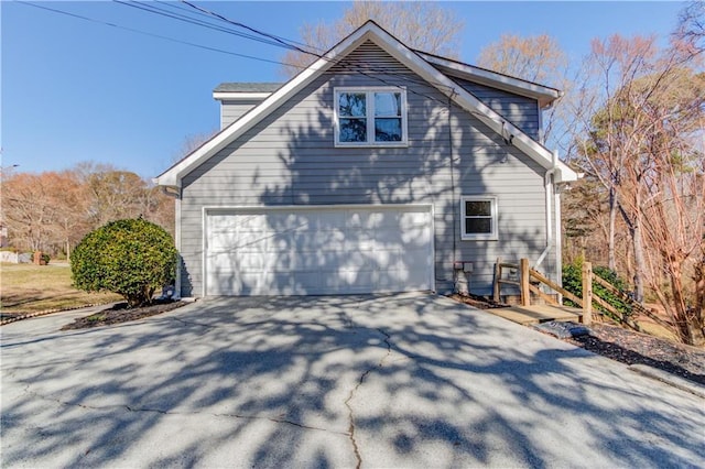 view of side of property with a garage and driveway