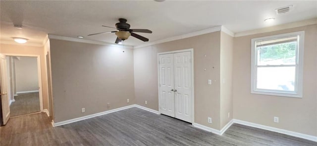 unfurnished bedroom with ceiling fan, crown molding, dark wood-type flooring, and a closet