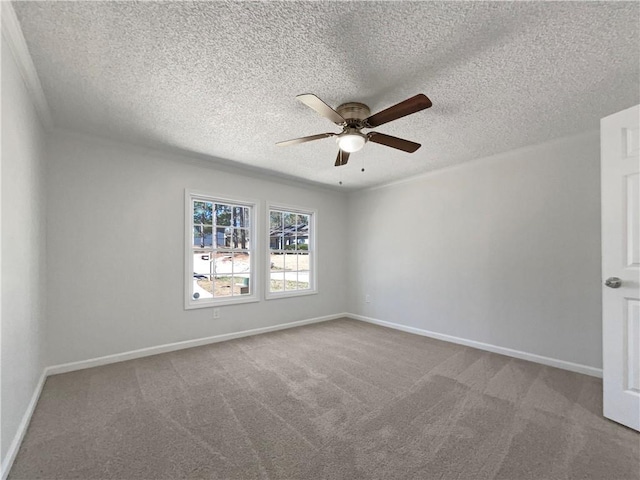 carpeted spare room with ceiling fan, baseboards, and a textured ceiling