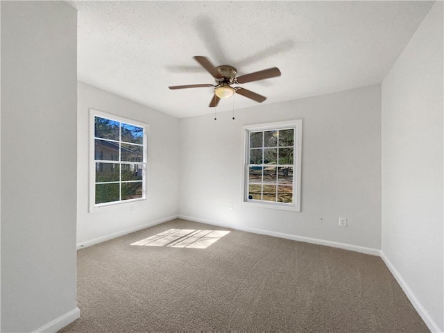 carpeted empty room featuring a ceiling fan, a textured ceiling, and baseboards