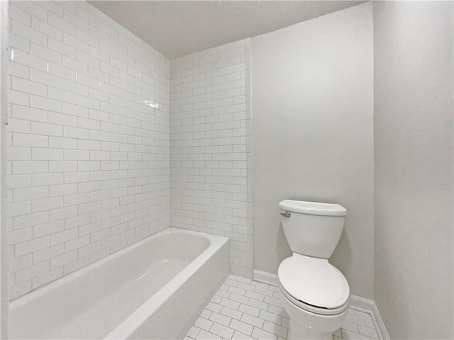 bathroom with tile patterned flooring, baseboards, and toilet