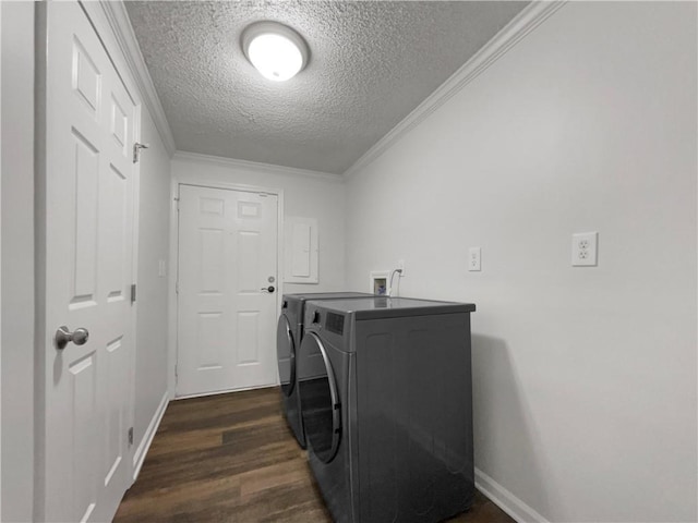 laundry room with dark wood-style flooring, ornamental molding, washing machine and dryer, a textured ceiling, and laundry area