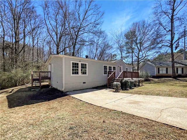 view of front of house featuring crawl space, driveway, a deck, and a front lawn