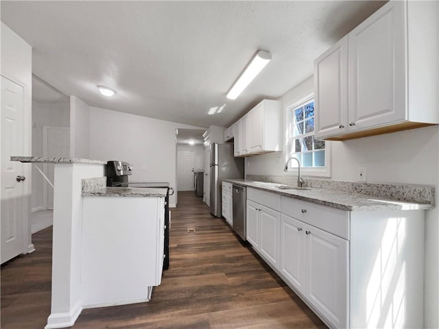 kitchen with stainless steel appliances, a sink, white cabinetry, light stone countertops, and dark wood-style floors