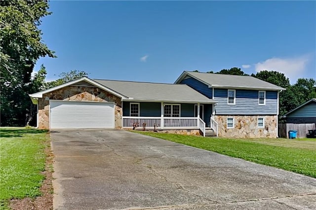 split level home with a porch, a front lawn, and a garage