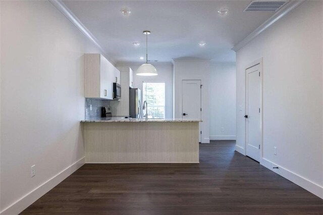 kitchen featuring stainless steel appliances, kitchen peninsula, dark hardwood / wood-style flooring, and hanging light fixtures