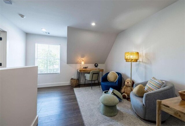 sitting room featuring dark wood-type flooring and vaulted ceiling