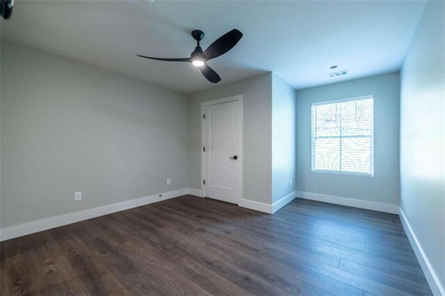 unfurnished bedroom with ceiling fan and dark wood-type flooring