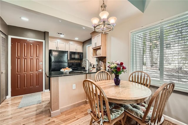 dining area featuring light wood finished floors, baseboards, visible vents, recessed lighting, and a notable chandelier