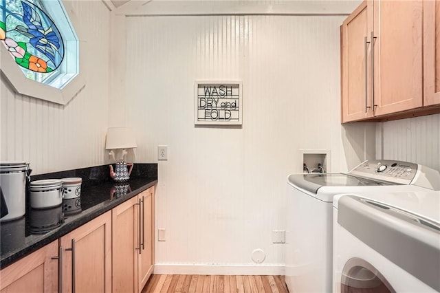 laundry area with cabinet space, light wood-type flooring, baseboards, and washer and clothes dryer