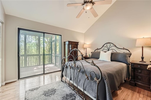 bedroom with vaulted ceiling, light wood finished floors, baseboards, and access to outside