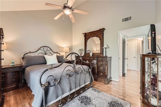 bedroom featuring wood finished floors, visible vents, high vaulted ceiling, and a ceiling fan
