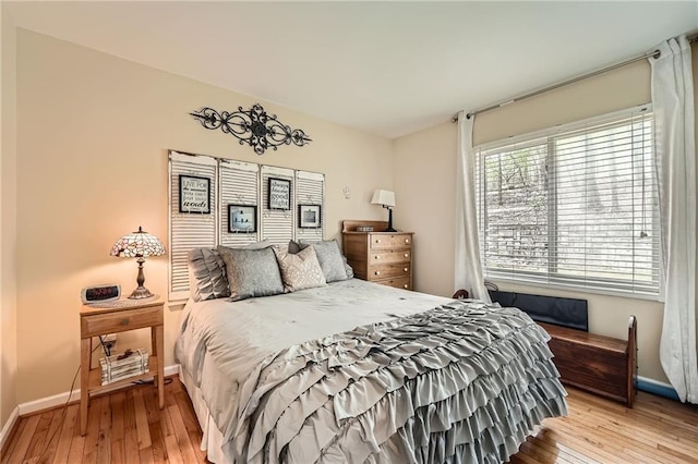 bedroom with wood-type flooring and baseboards