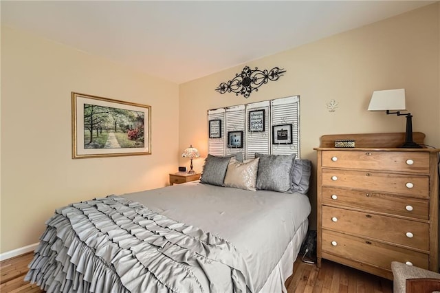 bedroom featuring wood finished floors and baseboards