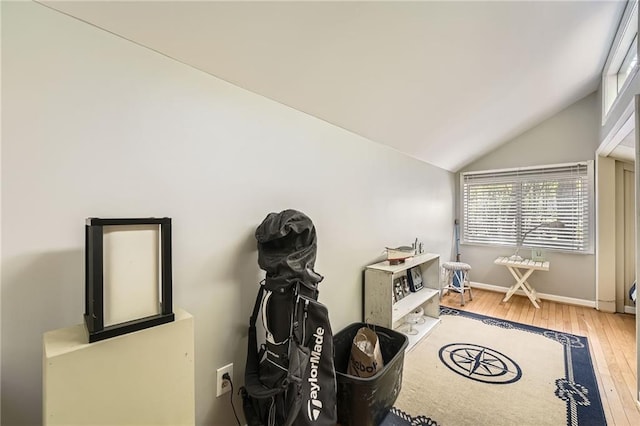 miscellaneous room with wood-type flooring, vaulted ceiling, and baseboards