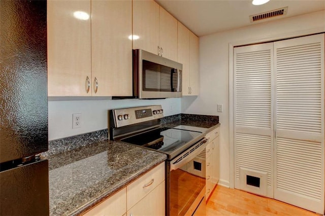 3481 Lakeside Dr NE Unit 902, Atlanta, GA 30326 - kitchen with appliances with stainless steel finishes, light wood-style floors, and dark stone countertops